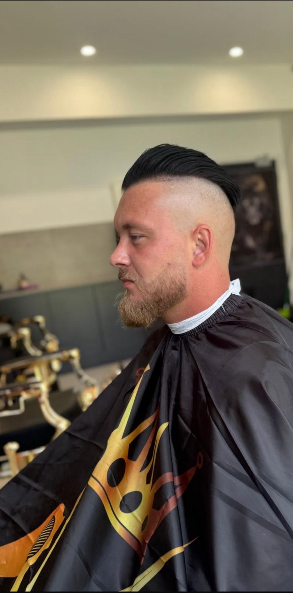High skin fade with a slicked finish and shaped beard by Fade Wave