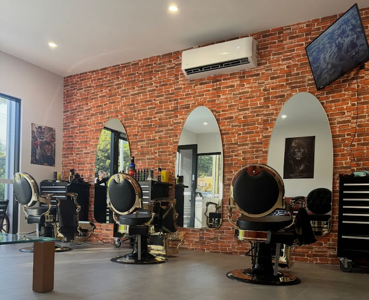 Fade Wave Barbershop interior with gold barber chairs and a brick feature wall